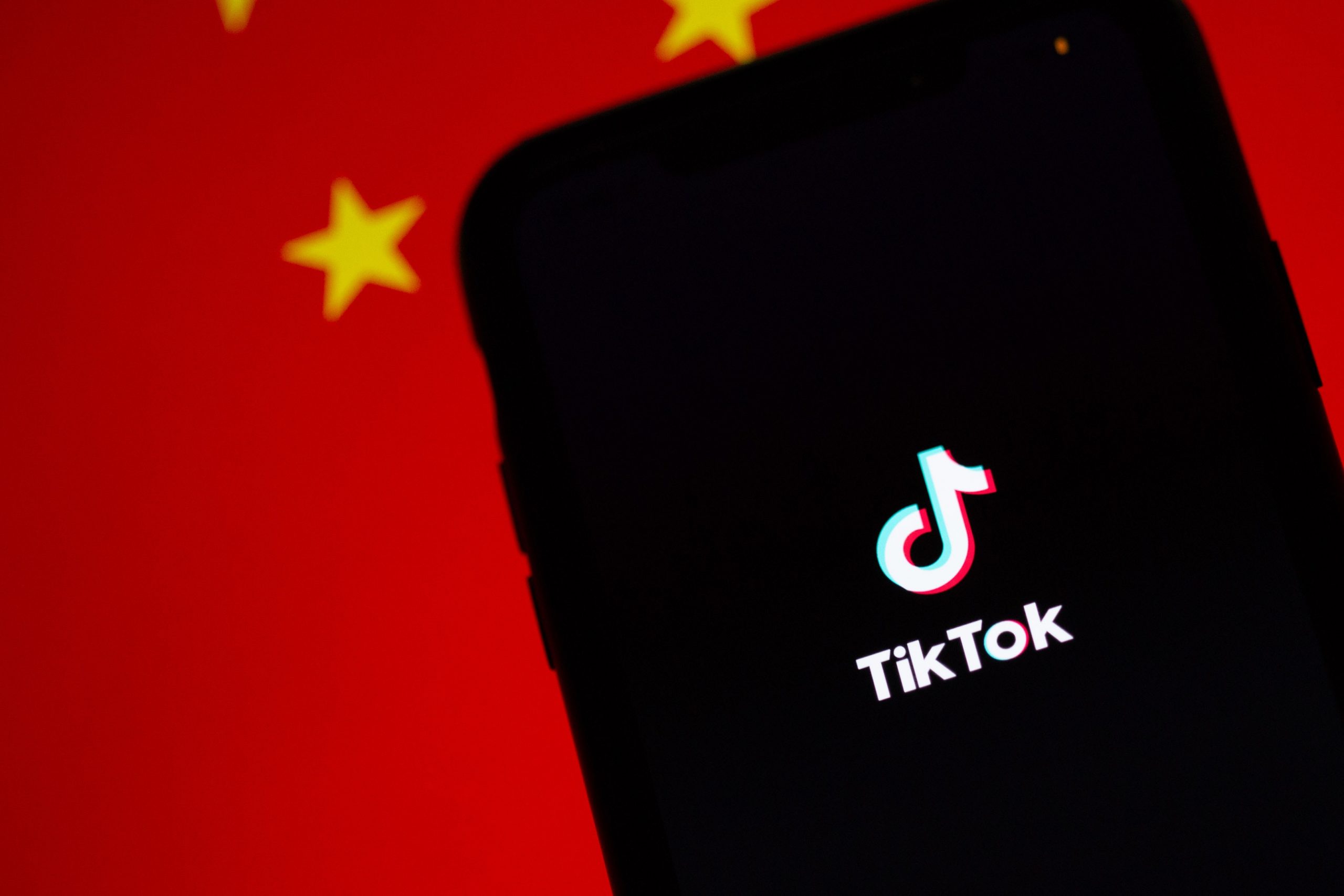 Un teléfono con el logotipo de TikTok delante de la bandera china.